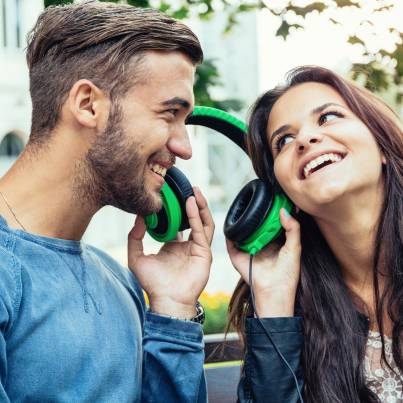 mężczyzna i kobieta trzymają słuchawki, słuchają ciekawostki muzyczne